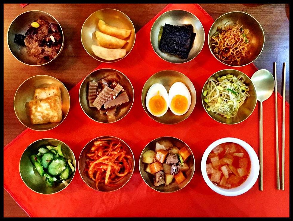 ‘n Tradisionele Koreaanse maaltyd. Van bo na onder, van links na regs: rys-en-pruimedantgereg, gebakte aartappelskywe, seegras, gerasperde soutvis, tofu, ‘n gekookte eier, weet nie, gepekelde komkommer, weet nie, beesbredie, kimchee.